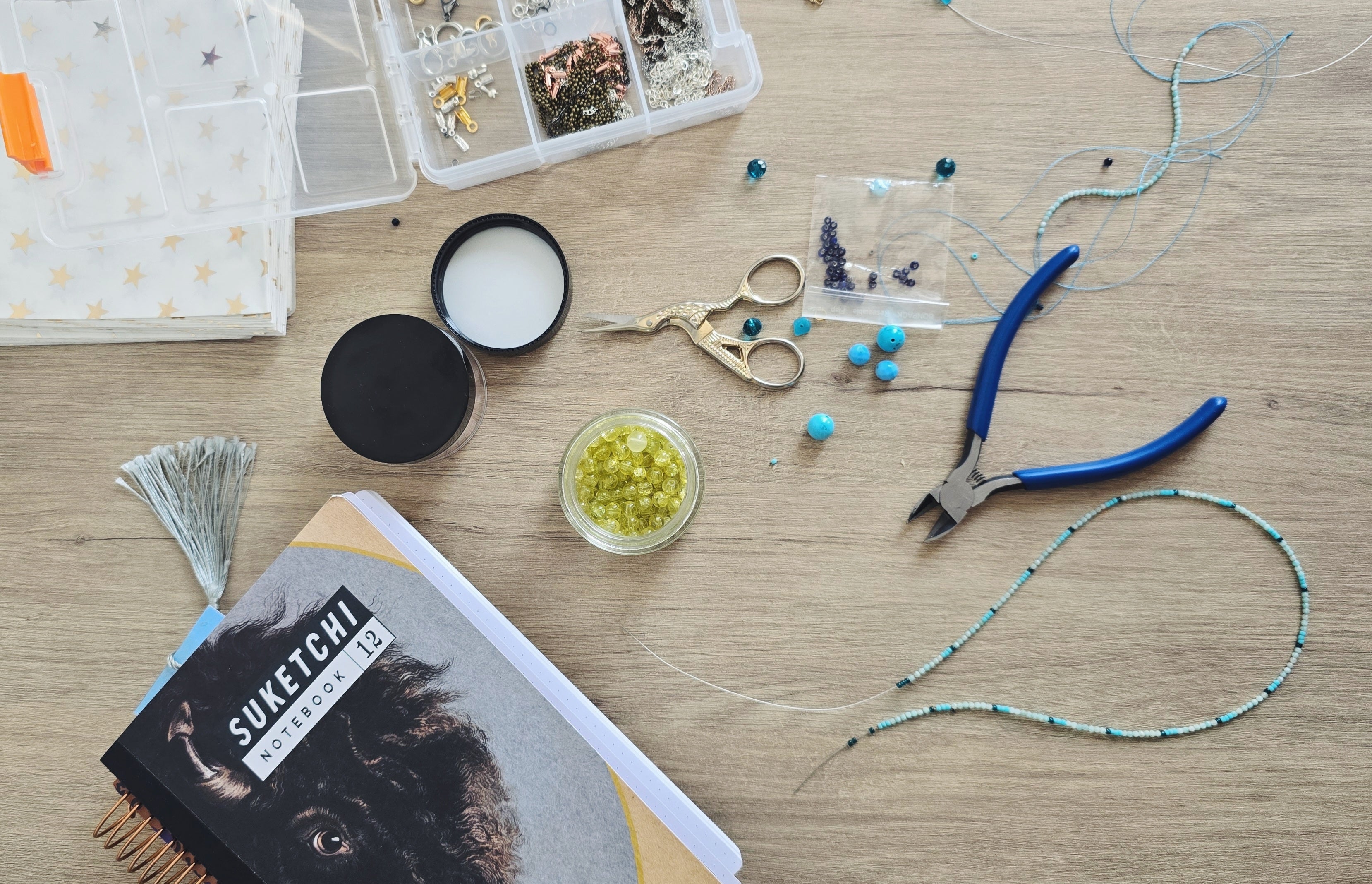Ceative process with handmade necklace and ocean blue beads. Set on the table