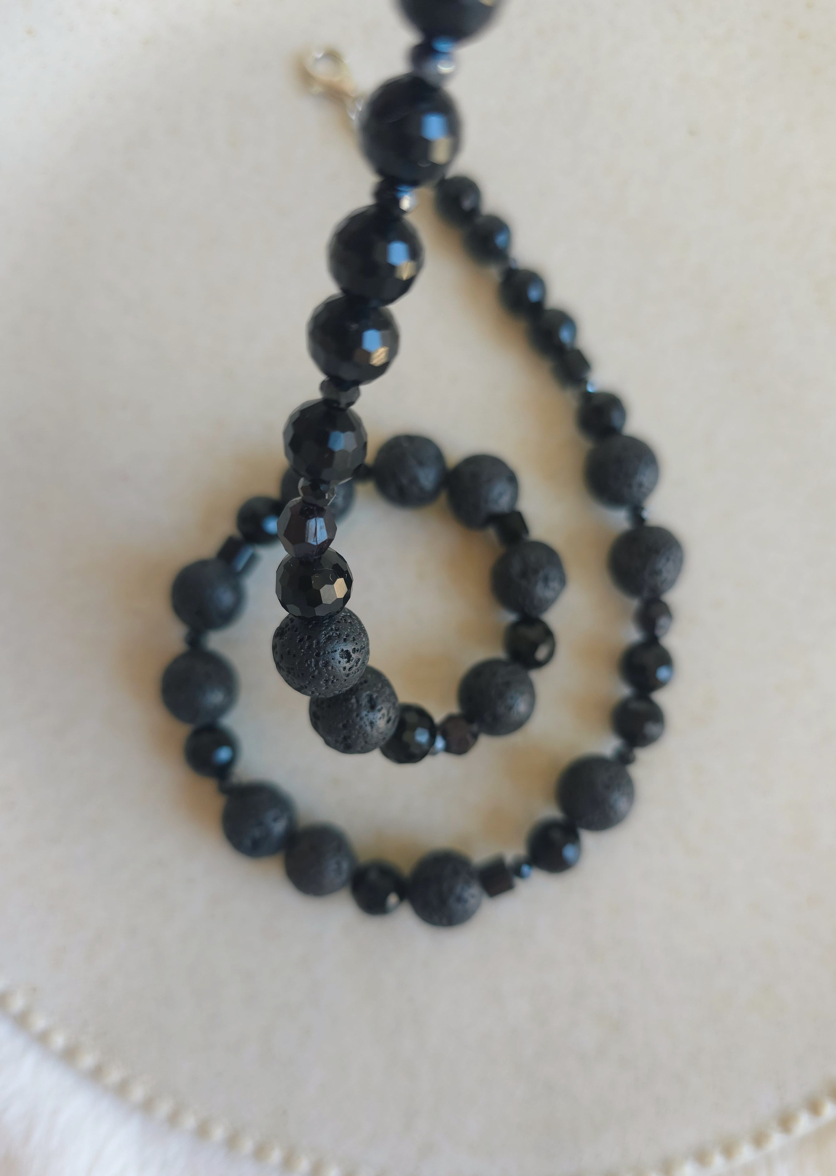 Black beaded necklace on a white surface