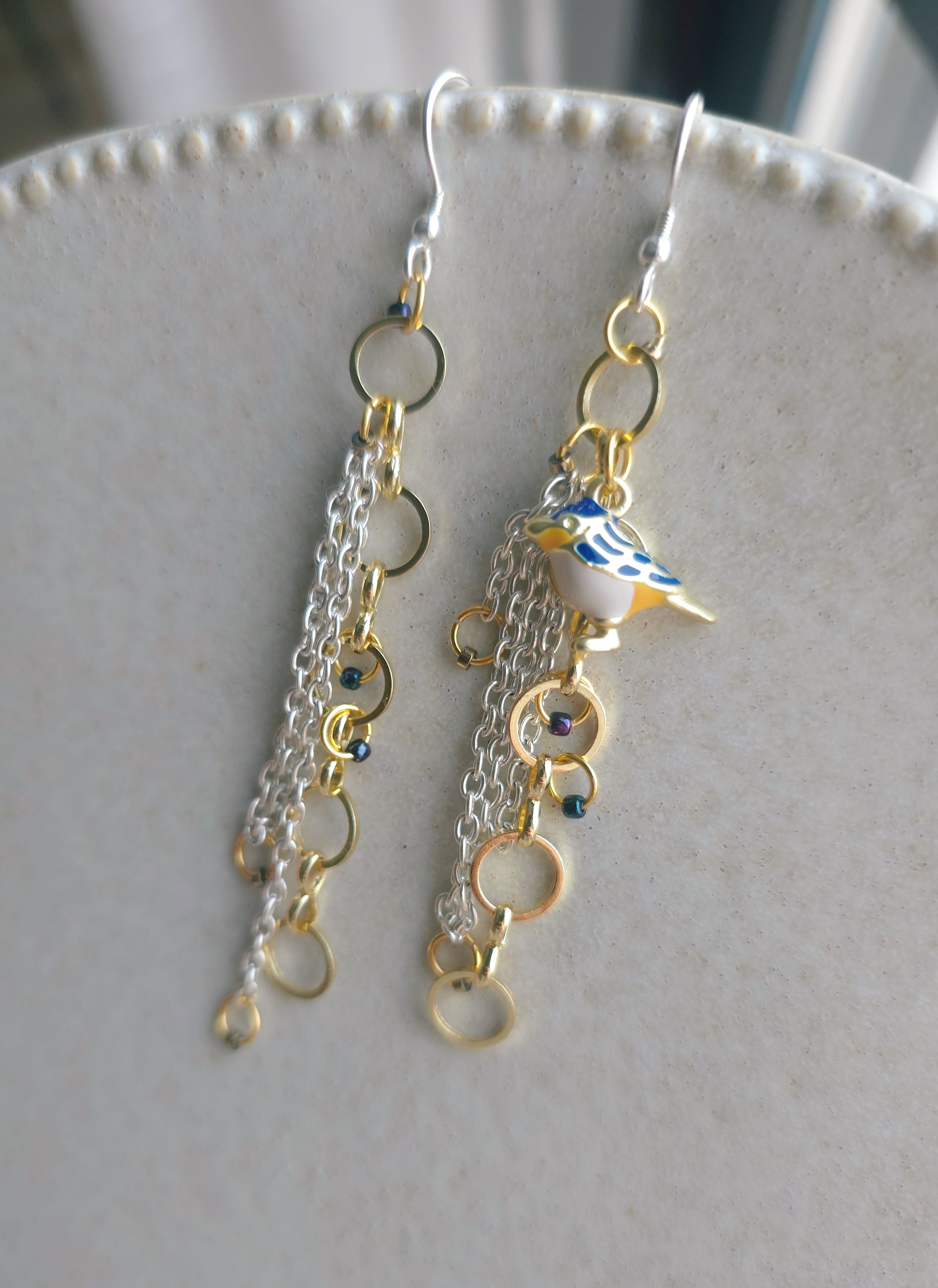 Ķēdīšu auskari sievietēm ar putniņa simbolu.