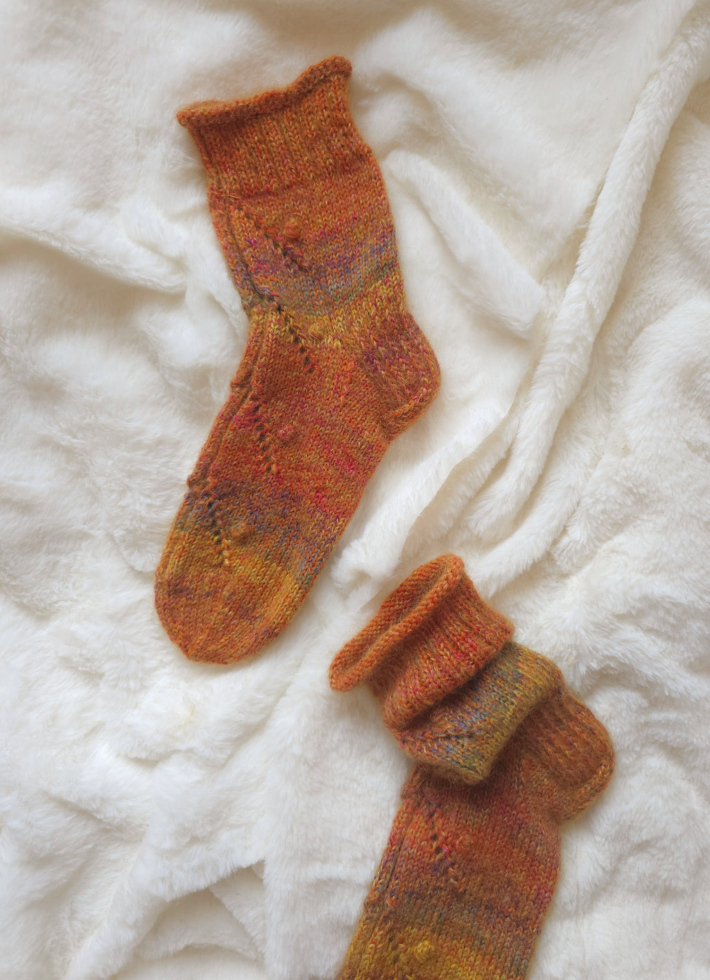 Pair of knitted orange merino socks for women with a warm color palette 