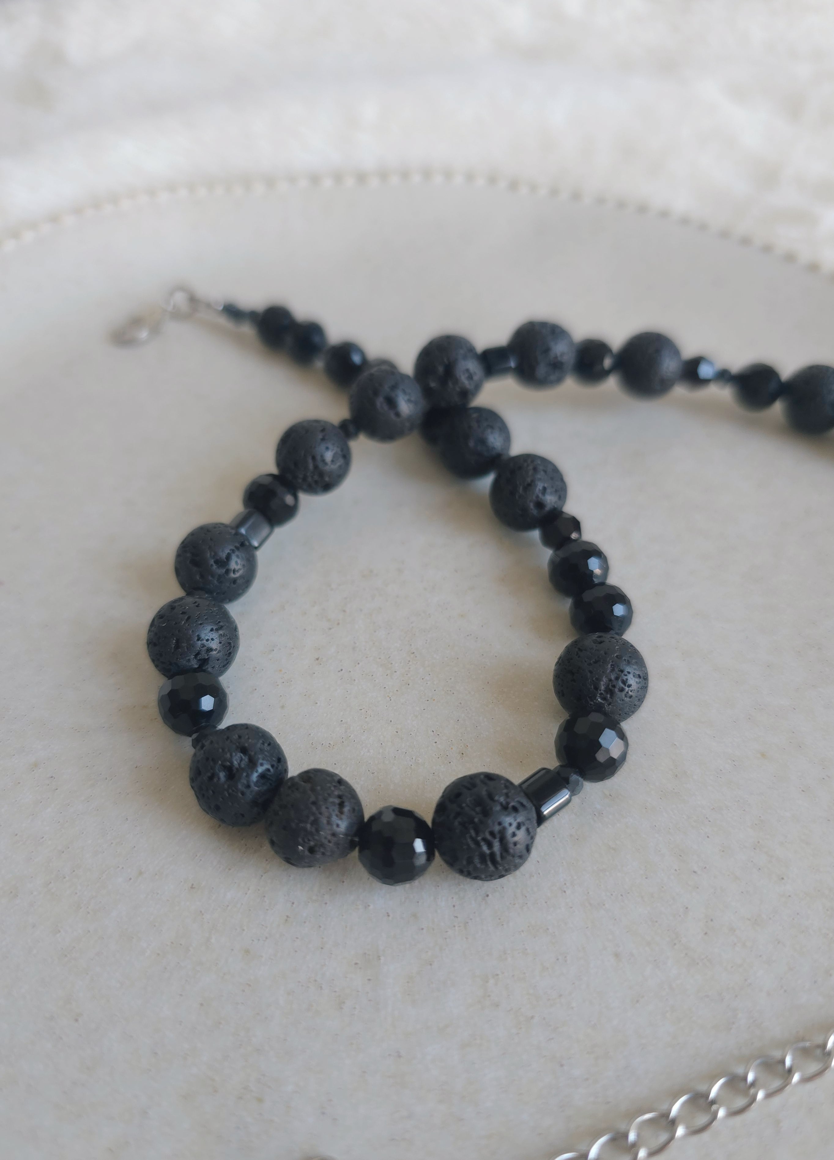 Dark black layering necklace on light surface